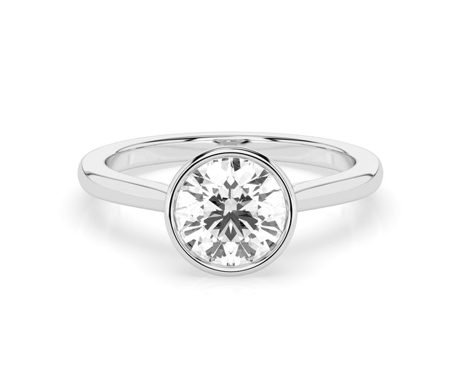 The Astra ring, featuring a 0.3ct round diamond in a bezel setting, is displayed against a white background.