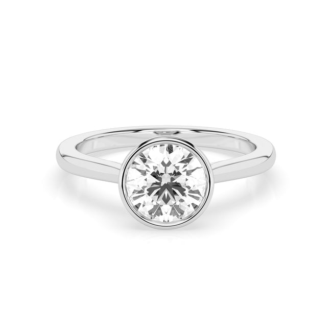 The Astra ring, featuring a 0.3ct round diamond in a bezel setting, is displayed against a white background.