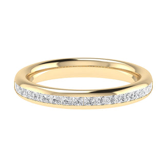 A slim gold band ring by Holts Gems, named “Channel Set Princess Cut,” featuring a row of sparkling princess cut white diamonds channel set along the top for a sophisticated and elegant look, photographed on a white background.