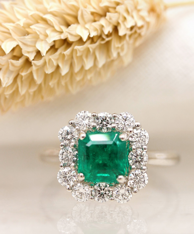 a emerald engagement ring in 18ct white gold set in a diamond halo style