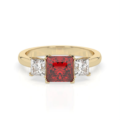 The Ruby Violet ring showcases a large, square-cut red gemstone at its center, flanked on each side by two smaller, square-cut clear gemstones, all set securely to beautifully highlight the stunning central stone.